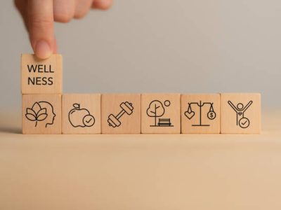 Holistic Wellness Concept. Wooden block with wellness icons, health care ,including mental well-being, fitness, nutrition, sleep, relationships and financial balance. Personal development and balance.